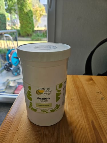 Customer's Geladrink Chrüterhüsli white plastic container on a wooden table.