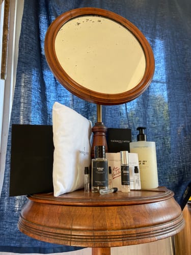 Customer's 50ml Fragrance & Body Wash Bundle displayed on a round vanity table with a mirror.