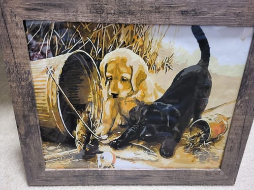 Customer's completed Custom Paint By Numbers pet portrait framed in wood, showing two puppies and a bucket.