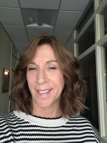 Customer's smiling selfie showing radiant skin after using The Micro Infusion System.