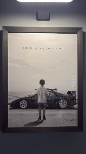 Customer's Black Oak Gallery Frame containing a print of a child standing before a sports car on a beach.