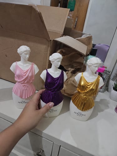Customer's three Kit Afrodite statues with pink, purple, and gold decorative tops held by a hand.