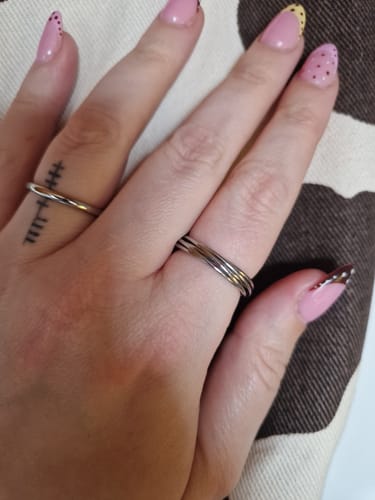 Customer's hand wearing the shiny, silver Twisted Mia Ring with a simple design.