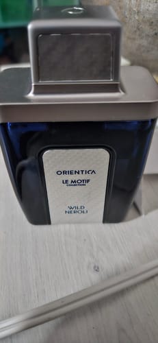Customer's Orientica Le Motif Wild Neroli perfume bottle, showing the dark blue glass and metallic silver cap.