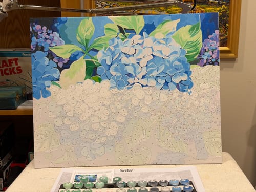 Customer's Blue Hydrangea paint-by-numbers kit in progress with paints and canvas on a table.