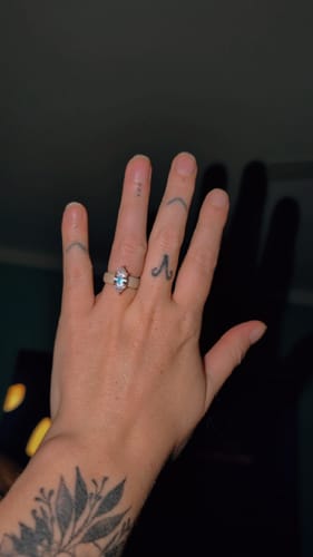 Customer's silicone ring with a marquise-cut stone worn on a hand with finger tattoos.