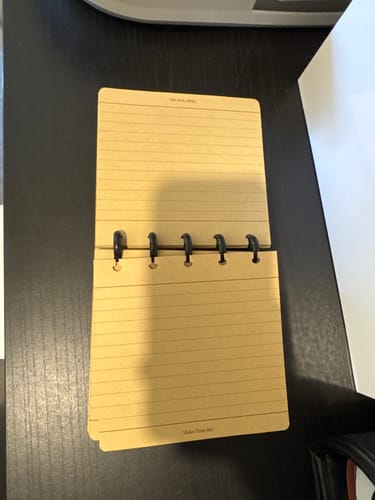 Customer's Crafted Rhythm notebook open, showing the flexible 5-hole mushroom binding system on kraft paper.