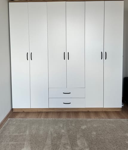Customer's Rani BA111 beyaz ve ceviz renkli, altı kapaklı ve çekmeceli geniş gardırop, kurulu halde odada duruyor.