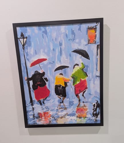 Reviewer's framed Custom Paint By Numbers portrait showing three people with umbrellas walking in the rain.