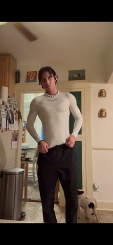 Customer wearing the Batman Compression Longsleeves in light grey, fitted style, standing in a kitchen.
