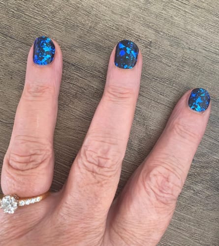 Customer's Blue Nightfall gel polish applied to three fingers, featuring a blue and black metallic flake pattern.