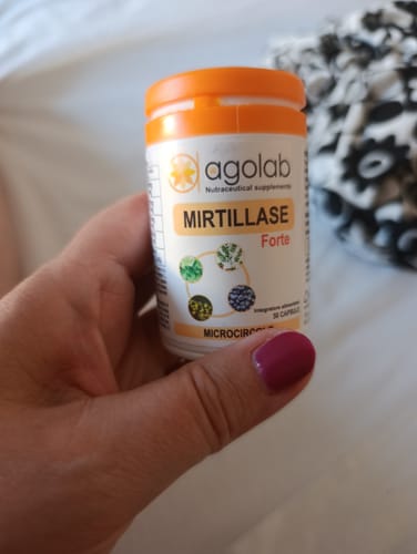 Recensione del cliente che tiene in mano un flacone di integratore Mirtillase Forte con tappo arancione.