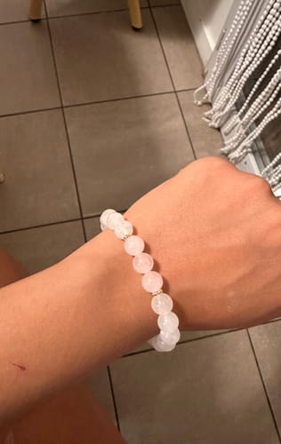 Reviewer's Bracelet Pierre de Lune et Quartz Rose worn on their wrist showing pale pink and iridescent stone beads.