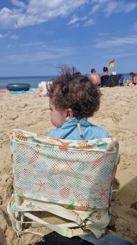 Customer's Sailor baby chair with seashell pattern sitting on a sandy beach.