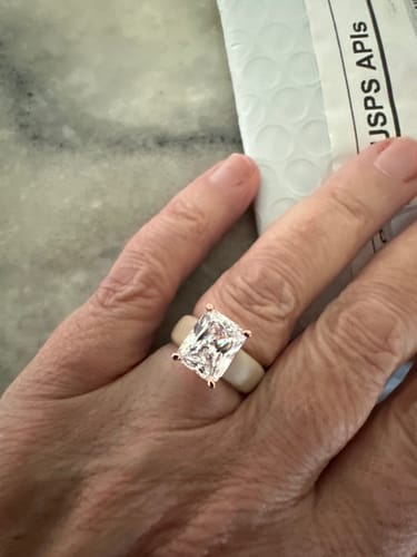 Customer's hand wearing a silicone ring with an emerald-cut stone setting.