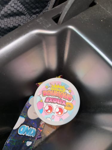 Customer's Boutique Exotics Uncle Snoop container with colorful, anime-style graphic design in a car cup holder.