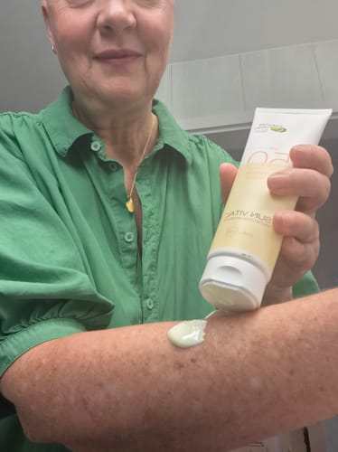 Reviewer's hand applying white Goloy Sun Vital Lotion onto their forearm.