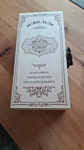 Customer's Leonardo Weinglas personalized wooden gift box with Vintage Jubiläum engraving on a wooden table.