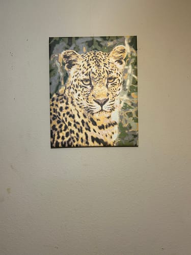 Customer's completed Custom Paint by Numbers Kit painting featuring a detailed portrait of a leopard hanging on a wall.