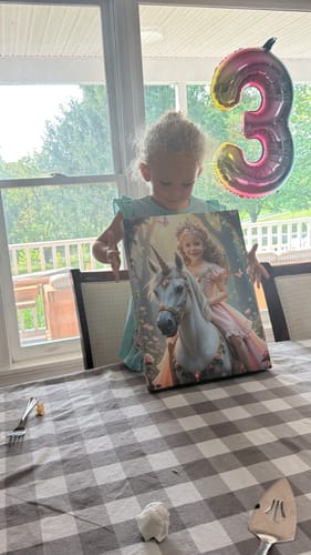 Customer's child holding The Enchanted Unicorn Princess wall art near a birthday balloon