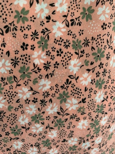 Customer's close-up of the Khaki and White on Peach Crepe Fabric featuring a small floral pattern