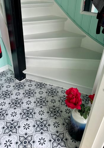 Reviewer's Copenhagen selvklebende fliser installed on a hallway floor next to white stairs.