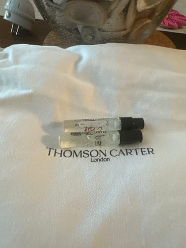 Customer's Are You Vanilla fragrance vials sitting on a white branded fabric pouch.