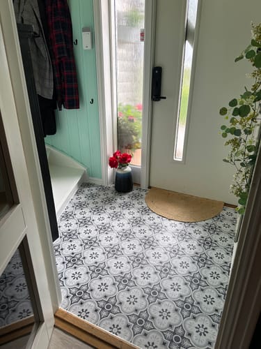 Customer's Copenhagen selvklebende fliser installed on a hallway floor with grey and white patterns.