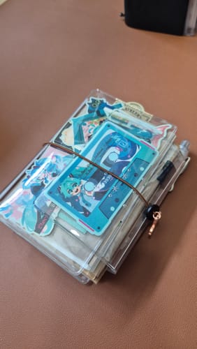 Customer's Clear Bloom TN passport journal with decorative stickers and a cassette tape illustration on the cover.