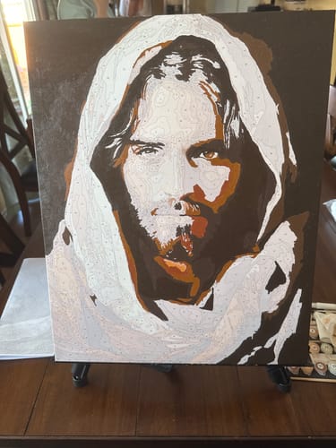 Customer's Cloaked Messiah paint by numbers canvas, partially painted with brown and white tones on an easel.