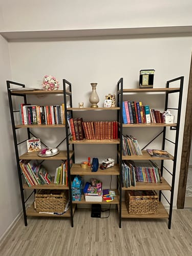 Customer's Rani HC107 metal bookshelf filled with books and decorative baskets in a home setting.