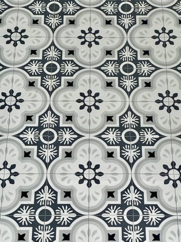Customer's close-up of installed Copenhagen selvklebende fliser showing the grey and white geometric pattern.