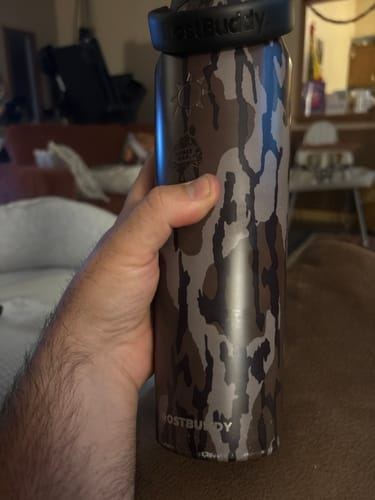 Customer's Mossy Oak Bottle Buddy held in hand, showing camo pattern and black lid details.