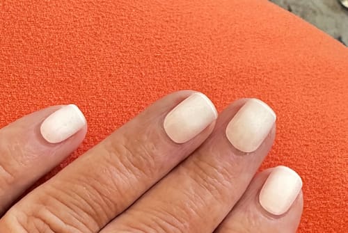 Reviewer's hand showing Blush Aurora UV Gel nail wraps after two weeks of wear.