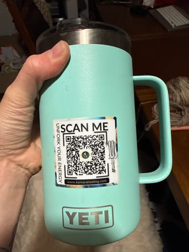 Customer's square sticker with a QR code and tuning fork illustration applied to a light blue travel mug.