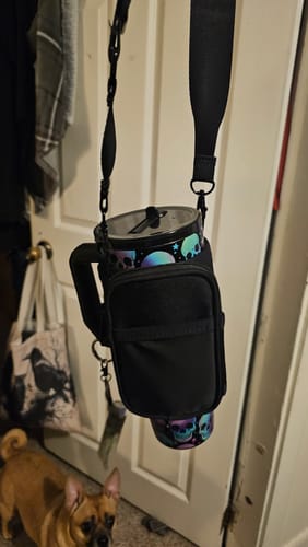 Customer's Thicc Buddy 40oz Crossbody Bag holding a black tumbler with skull patterns hanging from a strap
