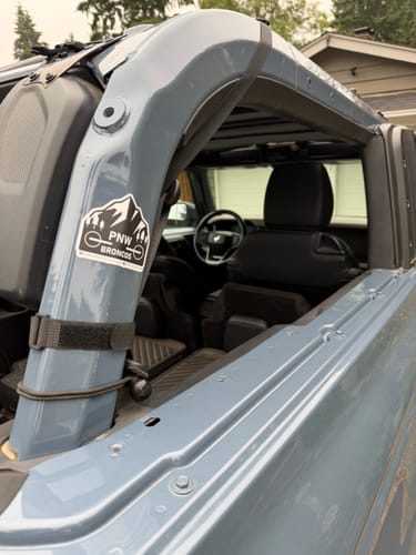 Customer's Custom Sticker applied to the side frame of a blue vehicle, showing a mountain graphic with PNW Broncos text.