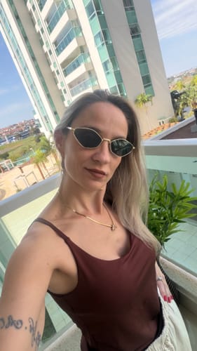 Reviewer's Óculos de Sol Capri com armação de metal geométrica, usando o acessório em um ambiente externo.