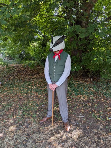 Customer's trousers made of greyish brown wool fabric worn in a costume outdoors.
