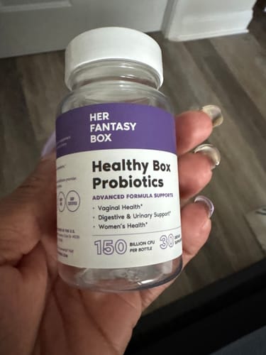 Customer's hand holding a bottle of Healthy Box Probiotics with a purple and white label.