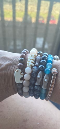 Customer's wrist showing The Voyage Bracelet alongside several other animal-themed beaded bracelets.
