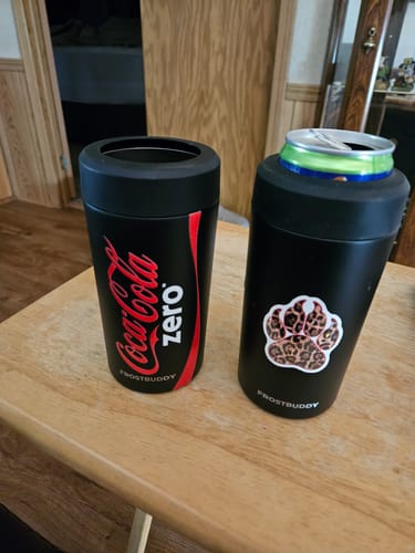 Reviewer's two black Universal Buddy can coolers sitting on a wooden table, one with Coca-Cola Zero branding.