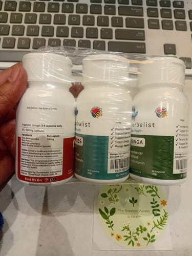 Customer's hand holding three white bottles of Reset Bundle supplements, each with a different color label.
