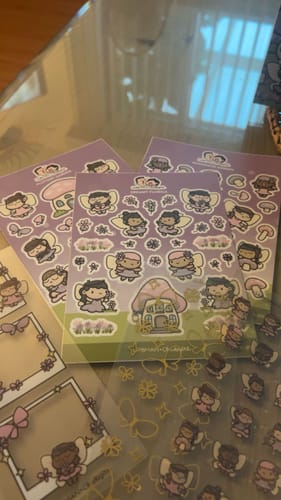 Customer's Sticker Subscription fairy and mushroom sticker sheets on a glass surface, including frames and characters.