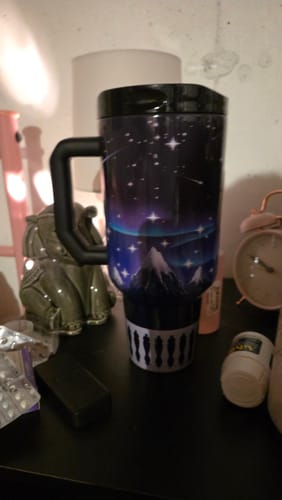Customer's Thicc Buddy 50oz mug with a night sky and mountain pattern, sitting on a table.