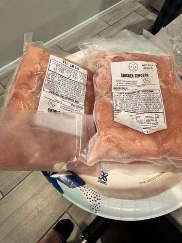 Customer's two 1 lb vacuum-sealed bags of Halal Chicken Tenders on a plate.