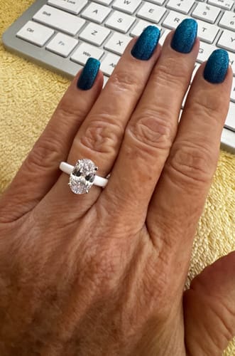 Customer's Rinfit silicone ring with an oval-cut stone worn on their finger.