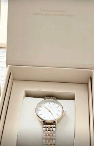 Customer's Ruby Petite gold and silver watch sitting inside its elegant branded packaging box.