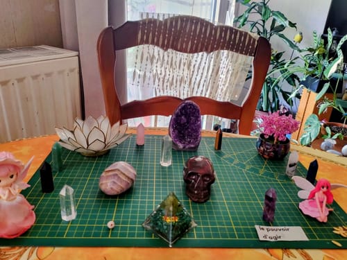Customer's collection of crystals, stones, and decorative figures arranged on a green cutting mat.