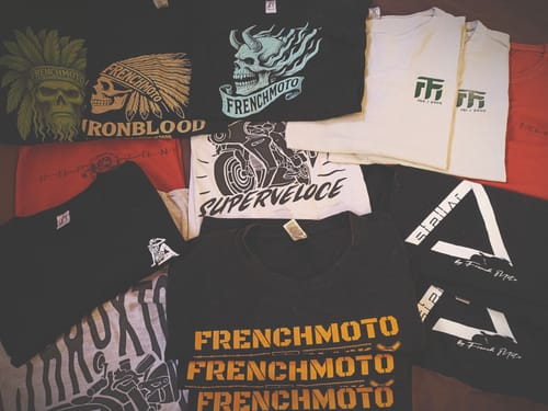 Reviewer's collection of various French Moto t-shirts laid out together, showing different graphic prints.